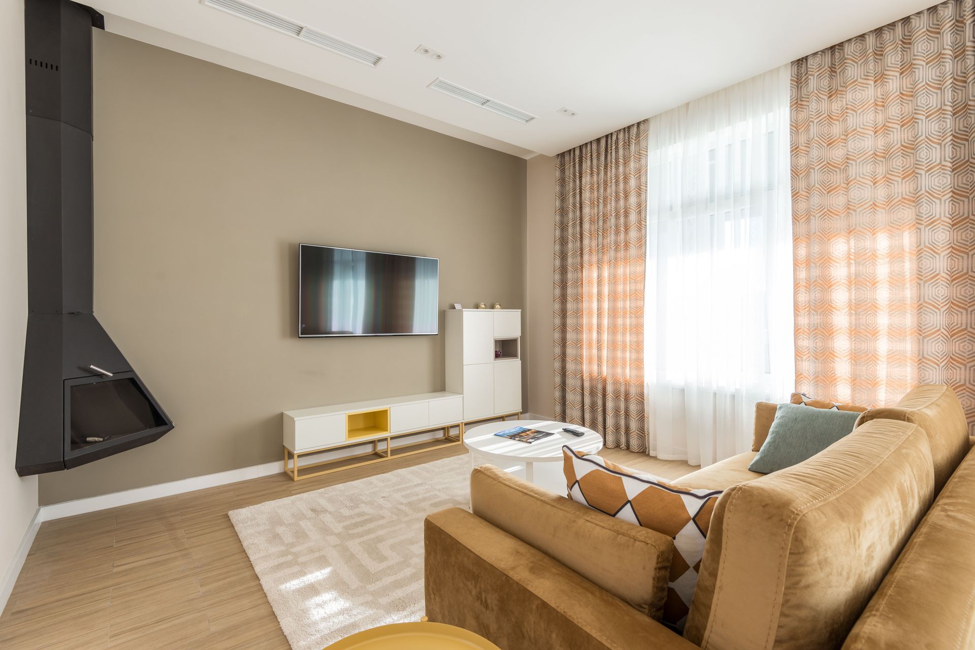 Stylish living room featuring a beige sofa, modern decor, and wall-mounted TV.