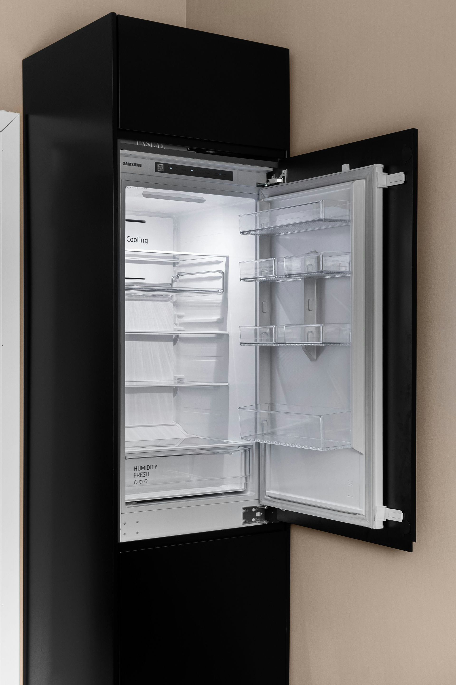 A black refrigerator with its door open in a kitchen